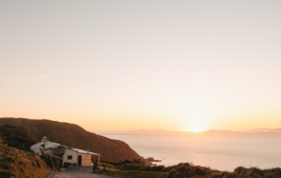 View of Boomrock lodge with the sun setting behind the South Island